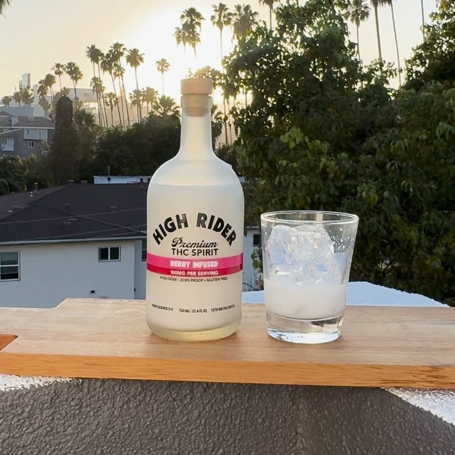 High Rider Spirit bottle beside a glass with ice on a rooftop