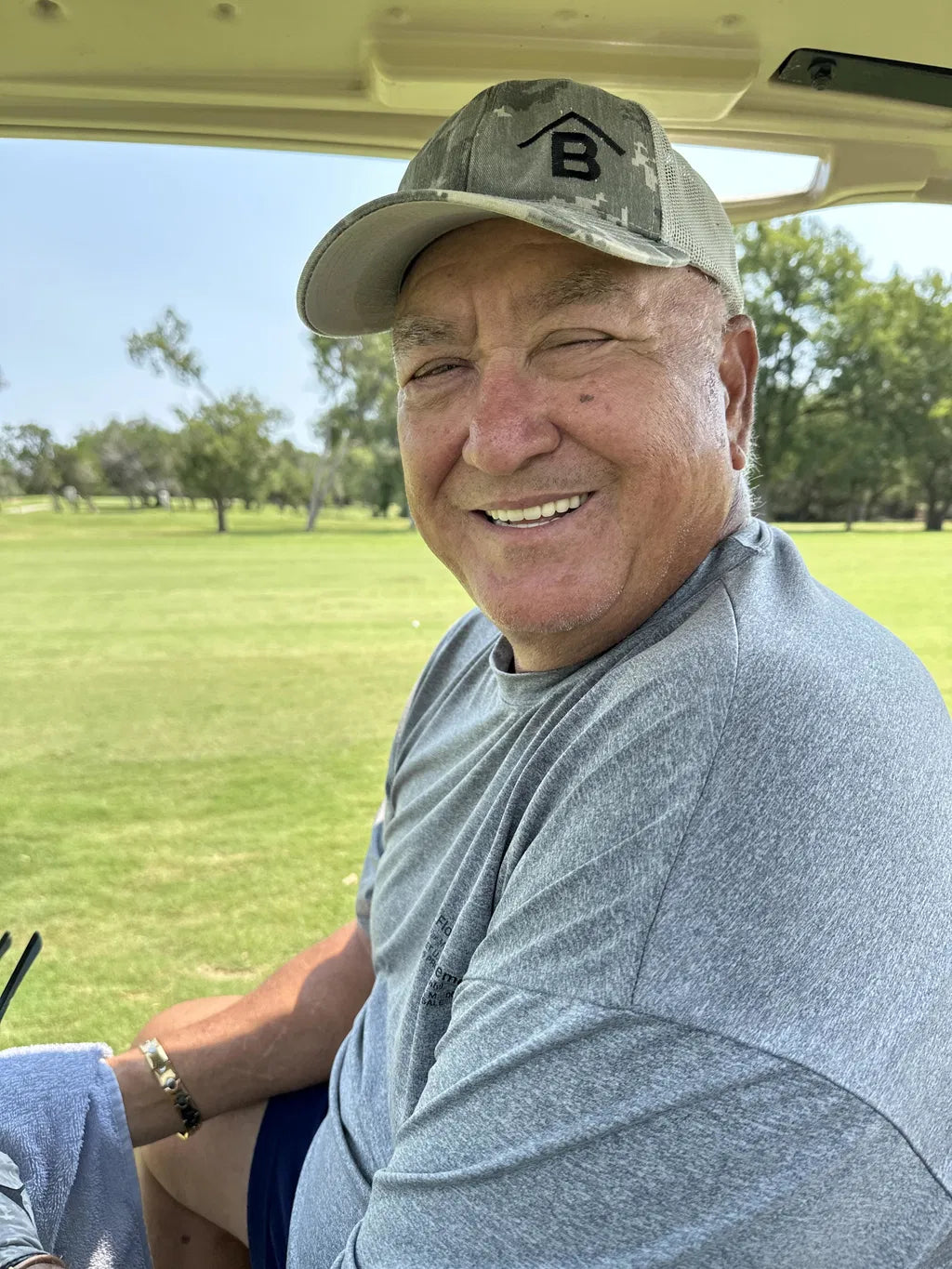 Jim smiling from a golf cart