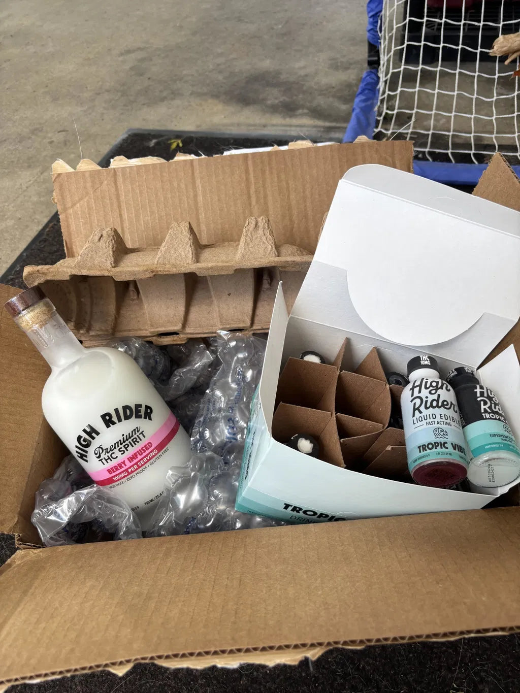 High Rider THC Spirit and liquid edible bottles unpacked from a delivery box