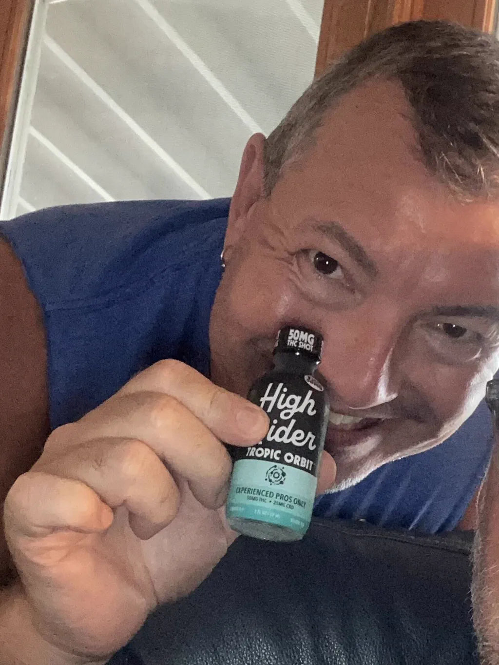 Tim holding a High Rider Tropic Orbit THC shot bottle